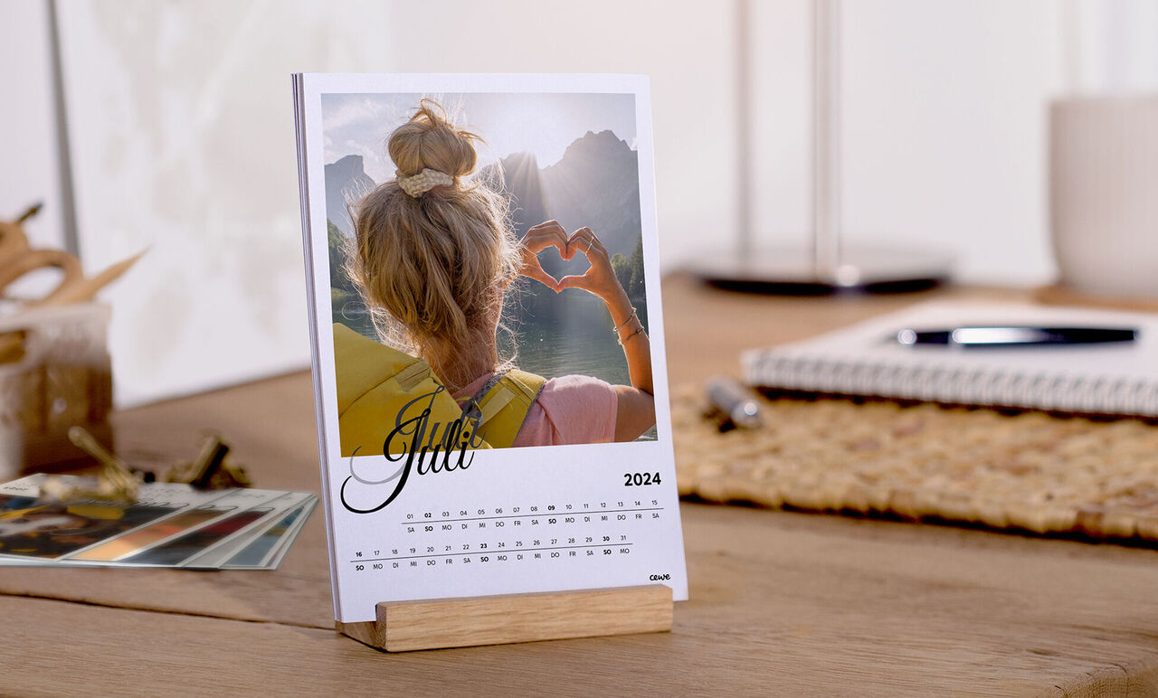 Calendar de birou gratuit pentru iunie 2025, cu o fotografie iubitoare a unei persoane formând o inimă cu mâinile.