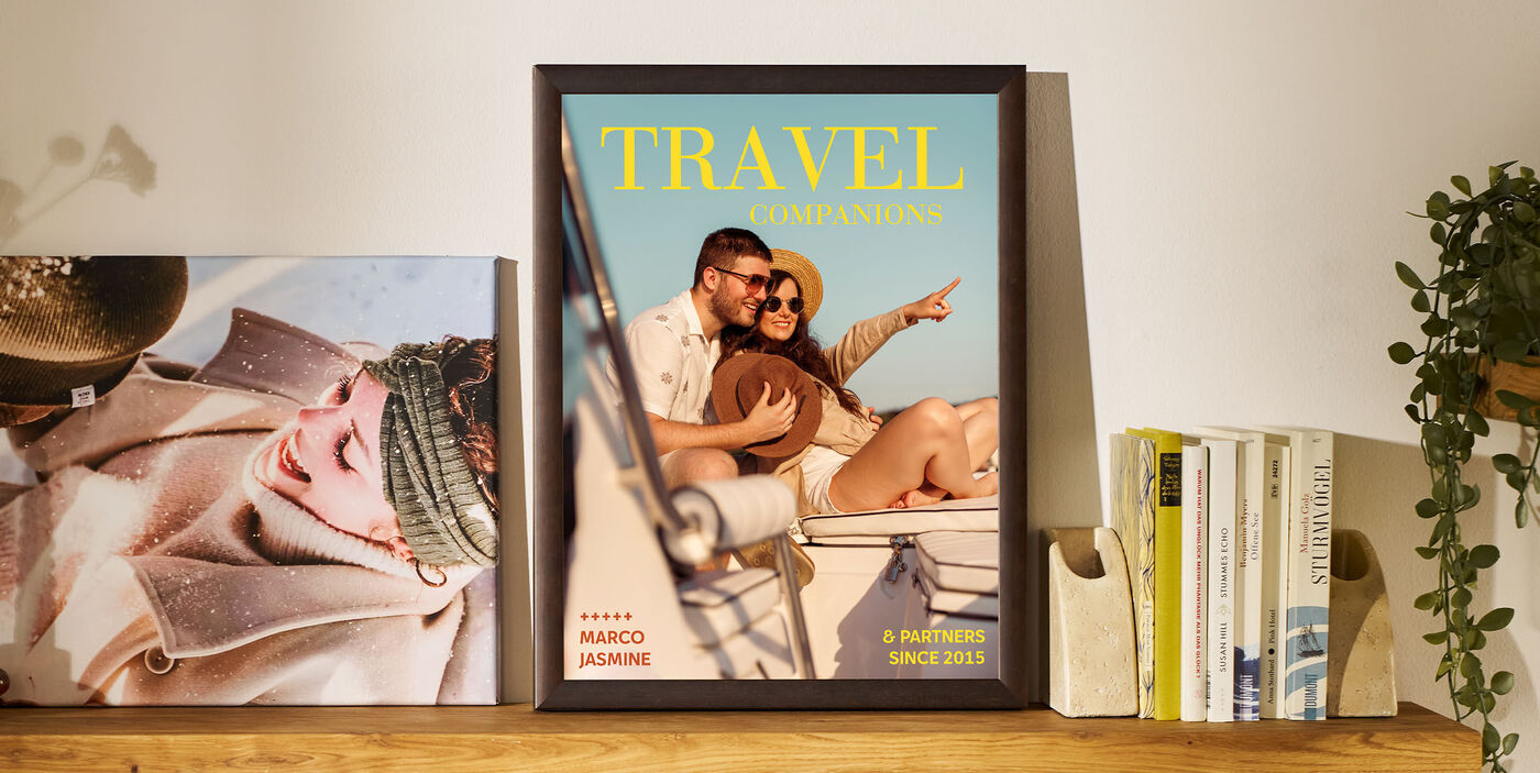 Un poster înrămat stă pe raft, între cărți și o plantă. Pe poster apare un cuplu călătorind cu vaporul, alături de textul „TRAVEL companions”. Alături se află o fotografie cu o femeie îmbrăcată în haine de iarnă.